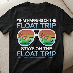 Könnte beinhalten: Schwarzes T-Shirt mit dem Text "WHAT HAPPENS ON THE FLOAT TRIP STAYS ON THE FLOAT TRIP". Das Design zeigt eine Sonnenbrille mit Sonnenuntergangshintergrund und zwei Frauen in Bikinis auf Schwimmreifen.