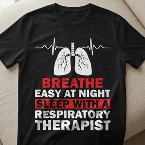 Könnte beinhalten: Schwarzes T-Shirt mit einer weißen Lungengrafik und einer Herzschlaglinie. Der Text lautet "Breathe Easy at Night Sleep with a Respiratory Therapist" in weißer und roter Schrift.