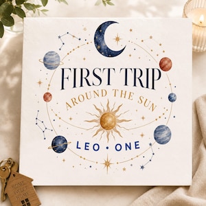 Peut inclure: Une plaque carrée blanche ornée d'une illustration céleste avec un croissant de lune bleu foncé, un soleil doré et diverses planètes. Le texte FIRST TRIP AROUND THE SUN LEO ONE est écrit en lettres bleu foncé et dorées, entouré d'étoiles.