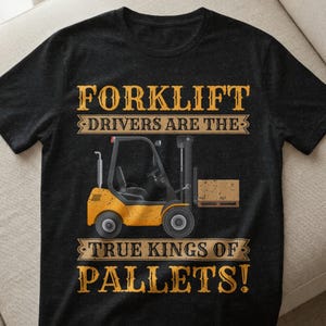 Puede incluir: Camiseta negra con un gráfico de carretilla elevadora amarilla y el texto "FORKLIFT DRIVERS ARE THE TRUE KINGS OF PALLETS!". La carretilla elevadora transporta un palé marrón.