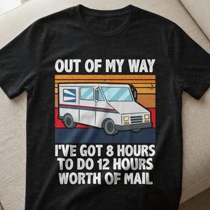Könnte beinhalten: Schwarzes T-Shirt mit einer Grafik eines weißen Postwagens und dem Text "OUT OF MY WAY" darüber. Unter dem Wagen steht der Text "I'VE GOT 8 HOURS TO DO 12 HOURS WORTH OF MAIL". Das Design hat einen Retro-Sonnenuntergangshintergrund.