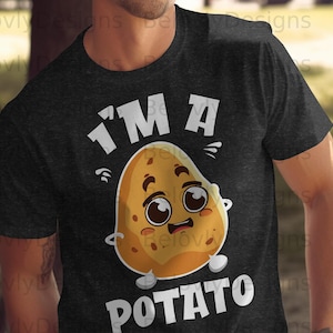 Può includere: T-shirt grigio scuro con la scritta bianca "I'M A POTATO". La maglietta presenta un personaggio di cartone animato a forma di patata con un'espressione sorpresa. La patata è marrone chiaro con macchie marroni scure.