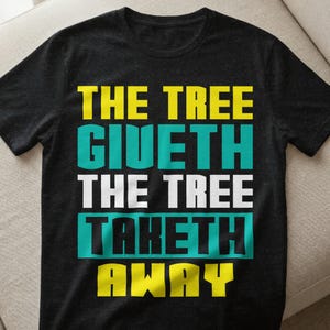 Könnte beinhalten: Schwarzes T-Shirt mit dem Text "THE TREE GIUETH THE TREE TAKETH AWAY" in gelben, türkisfarbenen und weißen Blockbuchstaben. Das Shirt hat einen Rundhalsausschnitt und kurze Ärmel.