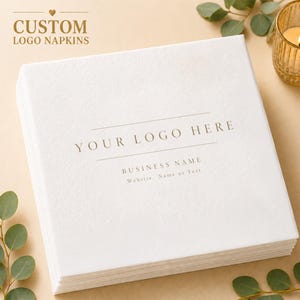 Könnte beinhalten: Ein Stapel weißer Servietten mit individuellem Logo. Auf den Servietten steht der Text "YOUR LOGO HERE" und "BUSINESS NAME". In der oberen linken Ecke des Bildes steht der Text "CUSTOM LOGO NAPKINS".