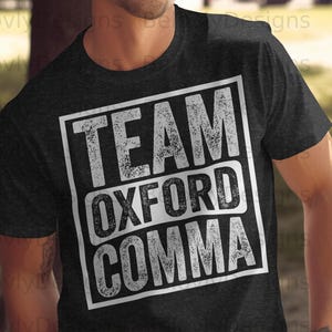 Può includere: T-shirt grigio scuro con la scritta "TEAM OXFORD COMMA" in un carattere bianco invecchiato all'interno di un rettangolo bianco. La maglietta è a girocollo.