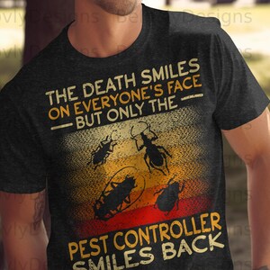 May include: Dark gray t-shirt with a graphic design featuring insects and the text "THE DEATH SMILES ON EVERYONE'S FACE BUT ONLY THE PEST CONTROLLER SMILES BACK". The design has a vintage, distressed look.