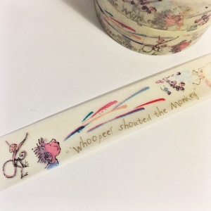 Könnte beinhalten: Ein weißes Washi-Tape mit einer goldenen Aufschrift, die "whoopee! shouted the monkey." lautet. Das Band zeigt außerdem ein farbenfrohes abstraktes Design und eine Zeichnung eines Affen und einer Person.