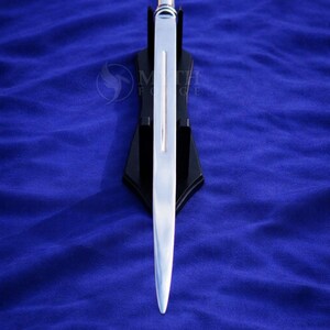 May include: A silver-colored sword with a polished blade, displayed on a black stand against a blue background. The sword has a straight, double-edged blade and a silver handle. The stand is angled.