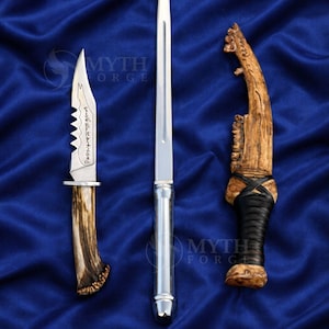 May include: Three handcrafted knives with unique designs. One has a serrated blade and antler handle, another is a long, slender blade with a silver handle, and the third has a wooden handle with leather wrapping.