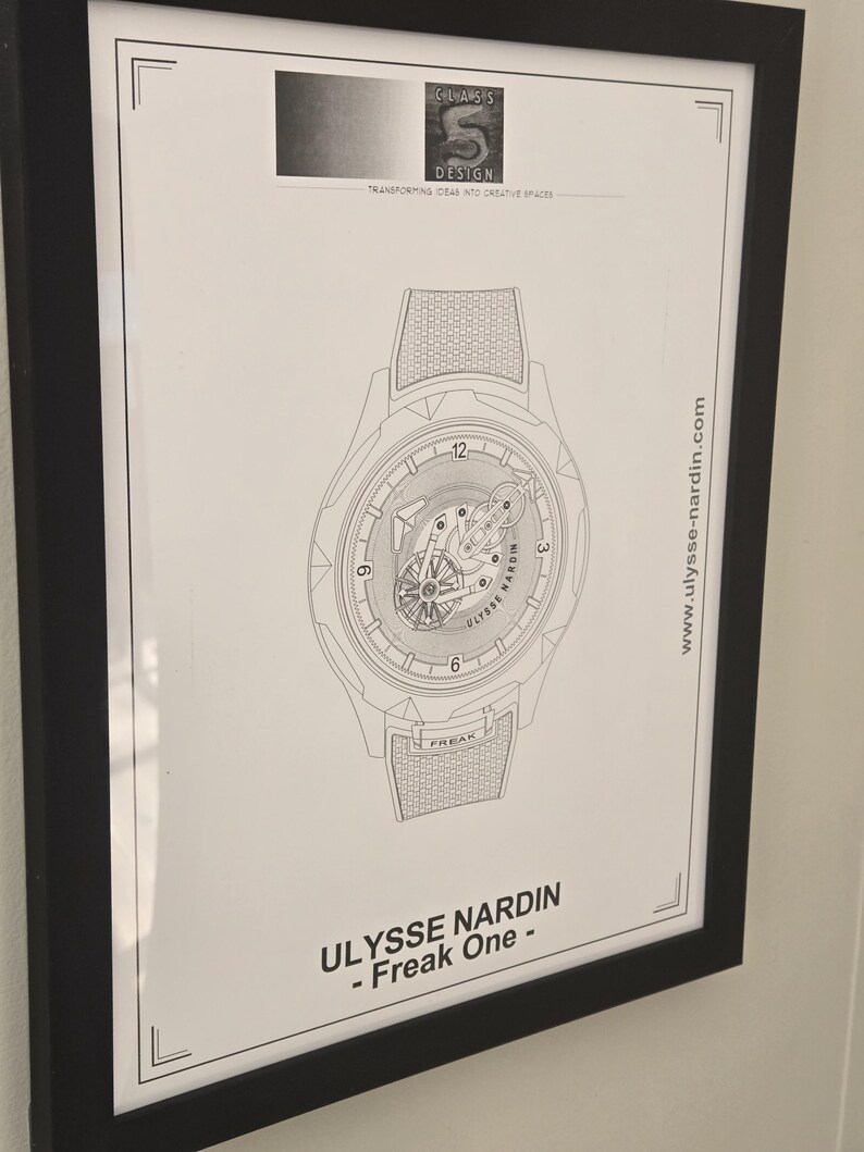 May include: Framed black and white print of a watch design. The watch illustration features intricate details, including the text "ULYSSE NARDIN - Freak One." The print also includes the website address www.ulysse-nardin.com and the "CLASS S DESIGN" logo.