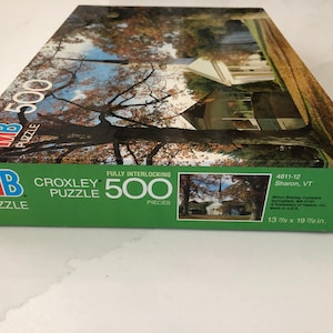 May include: A Croxley 500-piece puzzle box with a scenic image of a white building and trees. The box is green with the MB Puzzle logo and text that reads "CROXLEY PUZZLE 500 PIECES". The box dimensions are 13 7/8 x 19 7/8 inches.