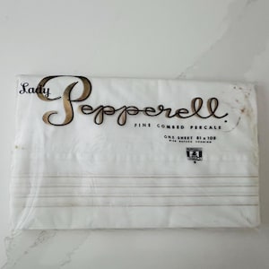 May include: A packaged white sheet set with the words "Lady Pepperell" in a cursive font. The package also includes the text "Fine Combed Percale" and "One Sheet 81 x 108". The sheet set has thin, horizontal stripes.