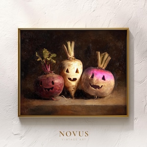 May include: A framed vintage art print featuring three carved root vegetables with smiling faces, reminiscent of jack-o'-lanterns. The artwork has a dark, moody background and a gold frame. The print is signed "NOVUS VINTAGE ART".