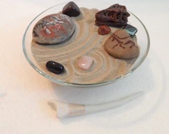 Primitive mini Zen garden in vintage glass dish. Dinosaur skull and mothman rock art.