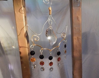 Suncatcher crystals with an abstract wire design hanger. Golden moon with assymetrical crystal drop.