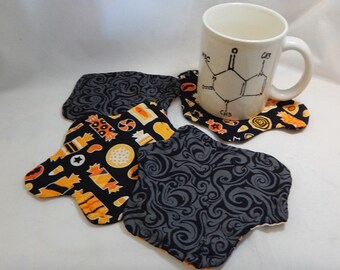 Halloween fabric coasters, reversible cotton hand-quilted set of four, Candy shop and black curliques. Splat shaped!