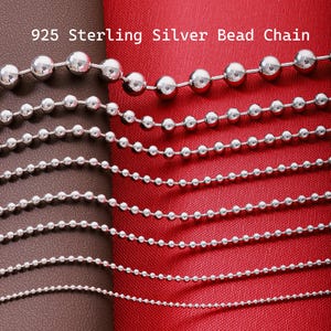 May include: A collection of 925 sterling silver bead chains arranged in descending order of bead size. The text 925 Sterling Silver Bead Chain is visible at the top. Each chain consists of polished spherical metal beads linked together.