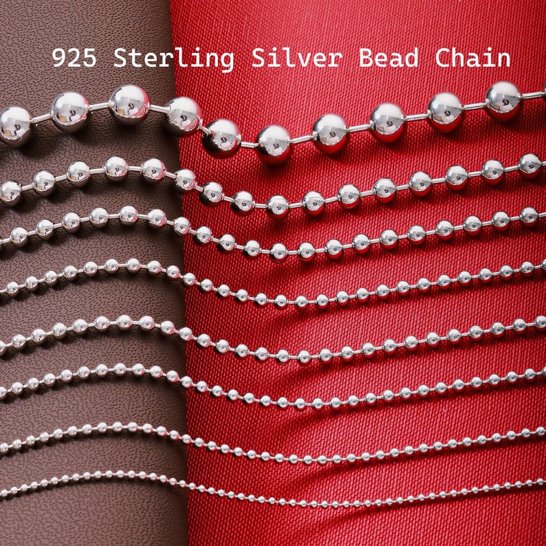 May include: A collection of 925 sterling silver bead chains arranged in descending order of bead size. The text 925 Sterling Silver Bead Chain is visible at the top. Each chain consists of polished spherical metal beads linked together.