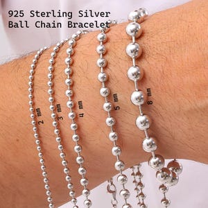 May include: 925 Sterling Silver Ball Chain Bracelet. Five silver bracelets with varying bead sizes labeled 2 mm, 3 mm, 4 mm, 5 mm, and 8 mm. The metallic spheres are connected in a continuous line, showcasing different thicknesses of the jewelry.