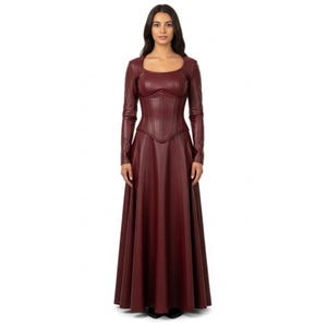 May include: A long, burgundy-colored dress with a fitted bodice and a flared skirt. The dress features long sleeves and a square neckline. The bodice has a corset-like design with vertical seams. The dress is made of a smooth, leather-like material.
