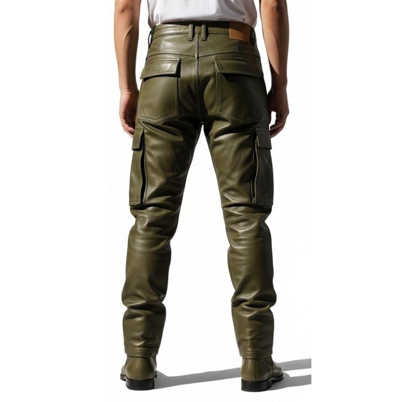 May include: Olive green leather cargo pants with multiple pockets and a belt loop. The pants have a classic cargo design with a straight leg fit. The leather appears to be smooth and has a slight sheen. The pants are shown from the back.