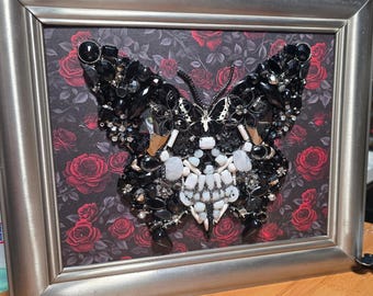 Biżuteria z czaszką i motylem – dekoracja ścienna w gotyckiej ramie