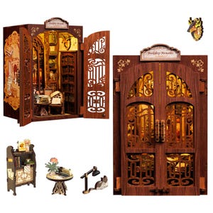 May include: A miniature wooden bookshelf model with an open door revealing a detailed interior. The model features intricate cut-out designs, a sign that reads "Bookshop Memories", and small furniture pieces, including a table and a lamp.