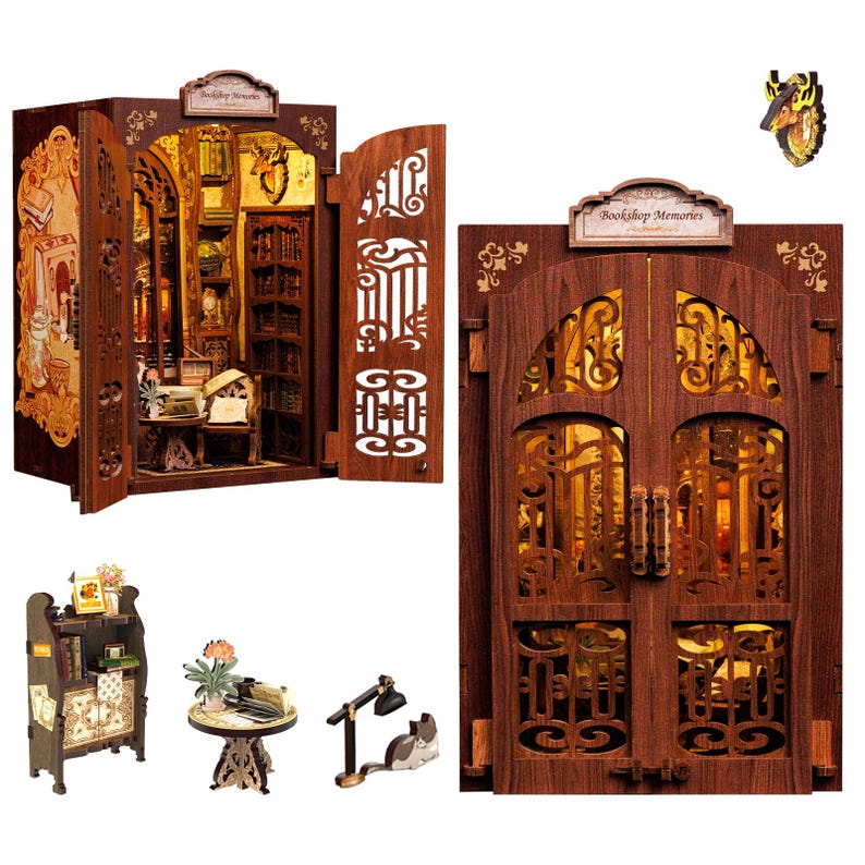 May include: A miniature wooden bookshelf model with an open door revealing a detailed interior. The model features intricate cut-out designs, a sign that reads "Bookshop Memories", and small furniture pieces, including a table and a lamp.