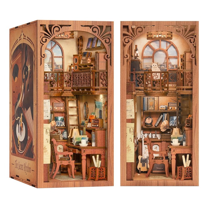 May include: Two wooden book nook models, each showcasing a detailed interior scene. One features a record player and the text "The Secret Rhythm." The other depicts a cozy room with a cat on a balcony, books, and vintage decor. Both are intricately carved.