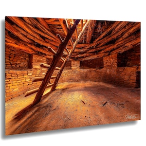 May include: Interior view of an ancient dwelling with a wooden ladder. The walls are made of reddish-brown bricks, and the ceiling is constructed of wooden beams. The room is lit by natural light, creating shadows. The scene evokes a sense of history.