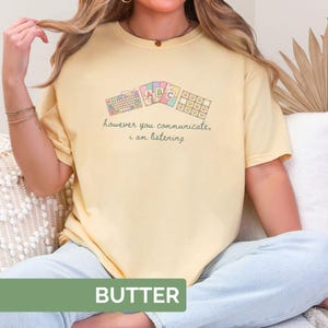 May include: Butter-colored t-shirt with a graphic of keyboards and the text "however you communicate, i am listening." The shirt also has the word "BUTTER" printed on the bottom.