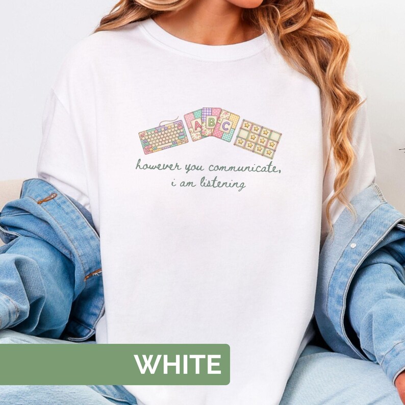 May include: White t-shirt with a pastel keyboard, ABC cards, and star-shaped icons design. The text "however you communicate, i am listening" is printed below the graphic. The word "WHITE" is printed at the bottom.