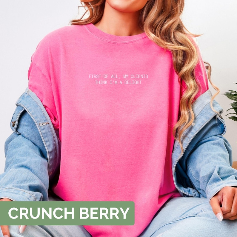 Puede incluir: Una sudadera rosa brillante con el texto blanco "FIRST OF ALL, MY CLIENTS THINK I'M A DELIGHT". La sudadera es parte de una colecci&oacute;n de ropa. La parte inferior de la imagen tiene un rect&aacute;ngulo verde con las palabras "CRUNCH BERRY".