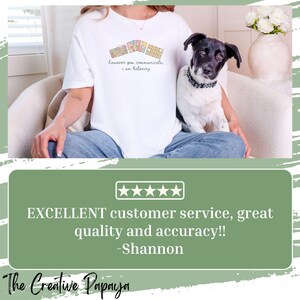 May include: White t-shirt with the text "however you communicate, I am listening" and a keyboard graphic. A black and white dog is sitting on a person's lap. The Creative Papaya logo is at the bottom.