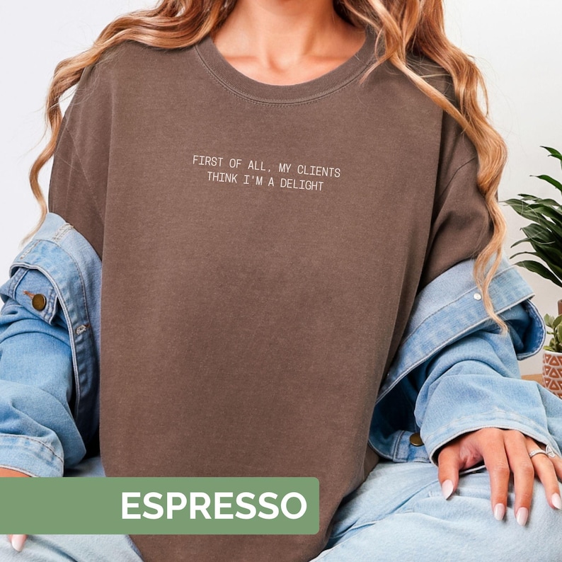 Puede incluir: Sudadera color espresso con el texto blanco "FIRST OF ALL, MY CLIENTS THINK I'M A DELIGHT". La sudadera es de color liso y tiene cuello redondo. La palabra "ESPRESSO" se muestra en un rect&aacute;ngulo verde en la parte inferior.