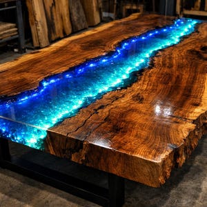 Puede incluir: Mesa de madera artesanal con un río central de resina epoxi azul y turquesa. La mesa tiene un acabado marrón oscuro y una base de metal negro. El río de resina está iluminado con pequeñas luces.