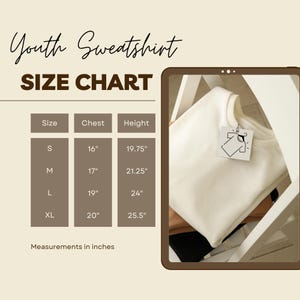 May include: Cream-colored youth sweatshirt with a size chart. The chart lists chest and height measurements in inches for sizes S, M, L, and XL. The sweatshirt is folded and has a tag attached.