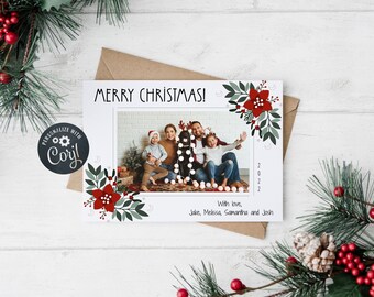以下が含まれることがあります： 家族写真と「MERRY CHRISTMAS！」の文字、花の装飾が施されたクリスマスカード。カードには2022年とJake、Melissa、Samantha、Joshの名前が記載されています。カードは緑のある白い表面にあります。