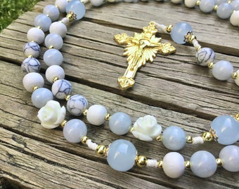 Rosario de la Reina del Cielo: Rosario católico hecho a mano con piedras preciosas de color azul pastel y rosas blancas.