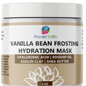 Op de afbeelding: Een witte pot met een bruin etiket waarop "Vanilla Bean Frosting Hydration Mask" staat. Het etiket vermeldt ook de ingrediënten: Hyaluronzuur, rozenbottel olie, kaolien klei en shea butter. De pot is 4 ounce.