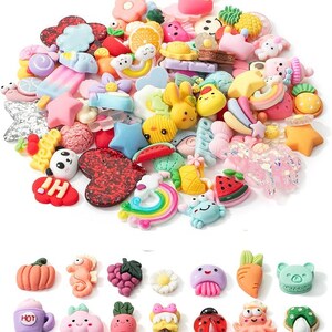 May include: A large collection of colorful resin cabochons featuring various shapes including rainbows, fruits, animals, stars, hearts, and sweets. The assortment includes items like a panda, crab, watermelon slice, and a cup with the text HOT printed on it.