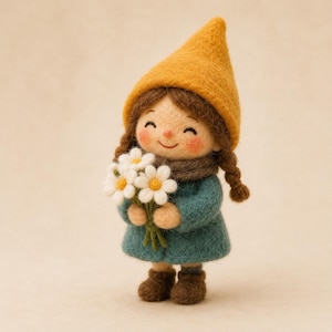 Puede incluir: Una muñeca de lana fieltrada con cabello castaño en trenzas, que lleva un gorro puntiagudo color amarillo mostaza, un abrigo verde azulado oscuro y botas marrones. La muñeca tiene mejillas sonrosadas y sonríe, sosteniendo un ramo de margaritas.