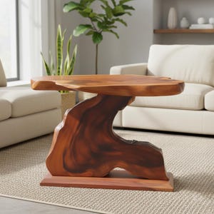 May include: A natural wood coffee table with a unique, organic design. The table features a thick, live-edge top supported by a sculptural base. The base is made from a single piece of wood, showcasing the natural grain and colour variations.