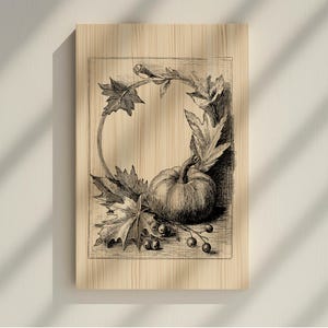 May include: A black and white illustration of a pumpkin, leaves, and berries arranged in a circular frame. The artwork is printed on a wooden panel, evoking a vintage or rustic aesthetic. The design is suitable for fall or harvest-themed decor.