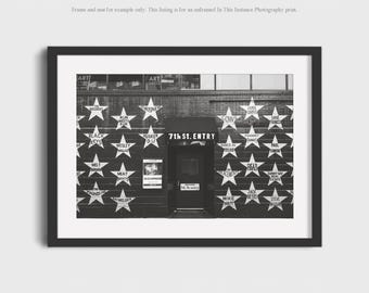 May include: Black and white framed print of the 7th St. Entry music venue. The facade features white stars with band names, and the venue's name is above the entrance. The print is a photography print.