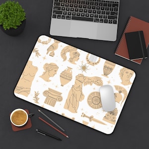 May include: A rectangular white mousepad with a black border, featuring a repeating pattern of tan Greek-inspired illustrations. The design includes busts, vases, and architectural elements. A computer mouse rests on the pad.