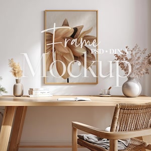 May include: A rectangular gold-toned frame containing a painting of a large, light brown flower, mounted on a white wall above a wooden desk. The text "Frame Mockup" and "PSD • DIN A" is overlaid in white across the centre of the image.