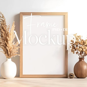 Könnte beinhalten: Ein Holzrahmen-Mockup mit dem Wort "Frame Mockup" in Weiß. Der Rahmen wird von einer weißen Vase mit hohem Trockengras und einer braunen Vase mit Trockenblumen flankiert. Ein Tannenzapfen liegt in der Nähe der Vase.