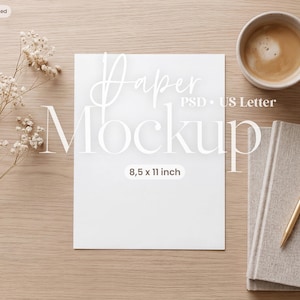 Può includere: Un mockup di carta rettangolare bianco con il testo Paper Mockup PSD US Letter 8.5 x 11 inch, accompagnato da una penna dorata, un taccuino grigio, una tazza di caffè e un rametto di fiori bianchi secchi su una superficie in legno chiaro.