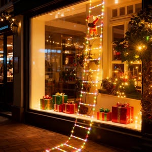 Puede incluir: Un escaparate navideño con una figura de Papá Noel subiendo una escalera de luces de colores. Se exhiben varias cajas de regalo envueltas en rojo y verde, creando un ambiente festivo.